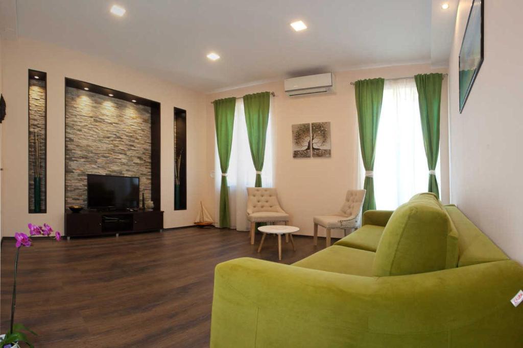 sala de estar con sofá verde y TV en Apartment Bacvice en Split