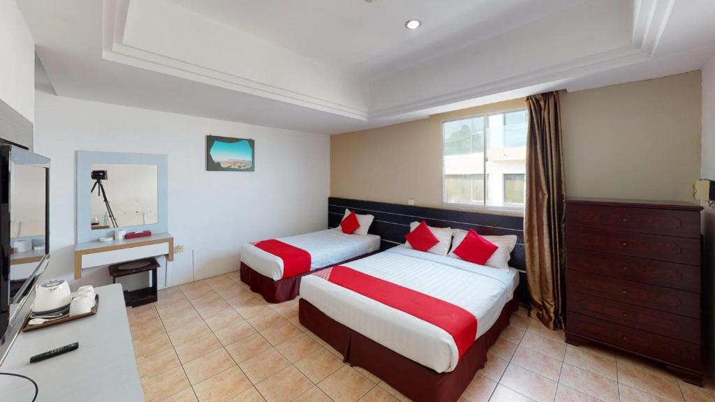 a hotel room with two beds and a desk at Hotel O Mayfair Hotel in Kuching