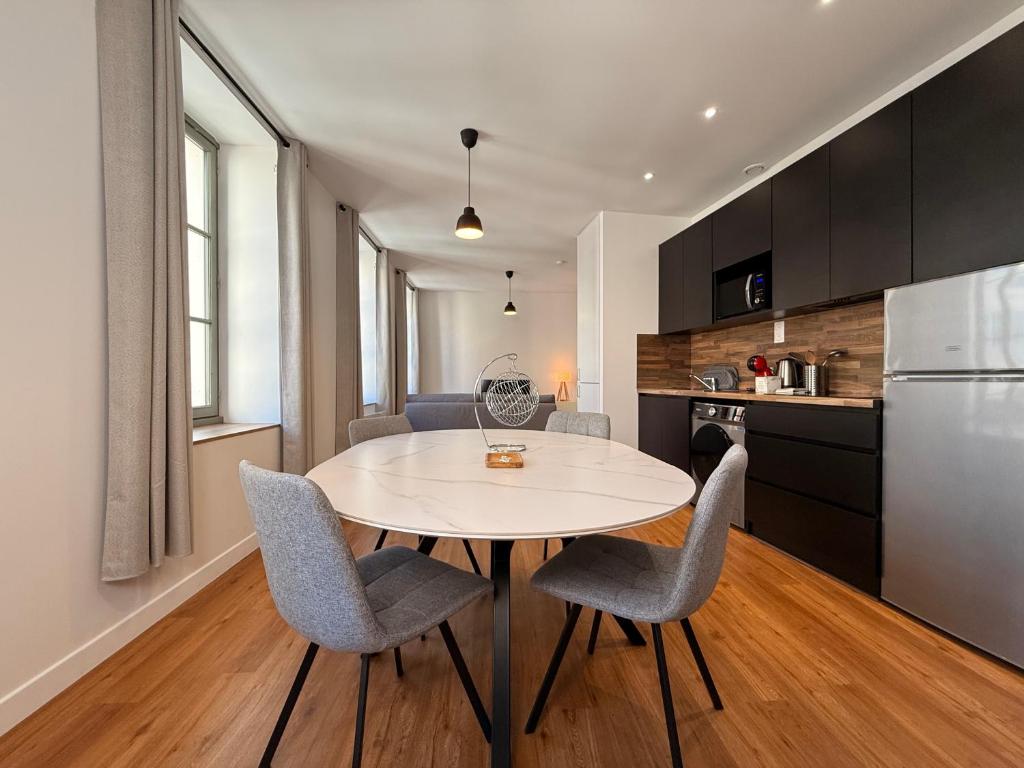 une cuisine et une salle à manger avec une table et des chaises dans l'établissement Le Moderniste Proche des Halles et Cathédrale, à Narbonne