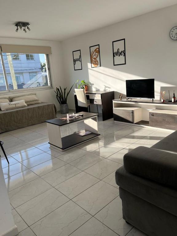 a living room with a couch and a table at Edificio Farfalle -Cochera incuida in La Plata
