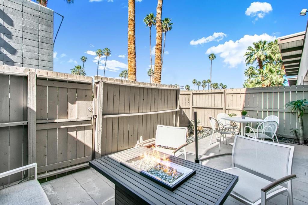 a patio with a table and chairs and a fire pit at Ocotillo Art Lounge - 1BR Posh Condo in South PS in Palm Springs