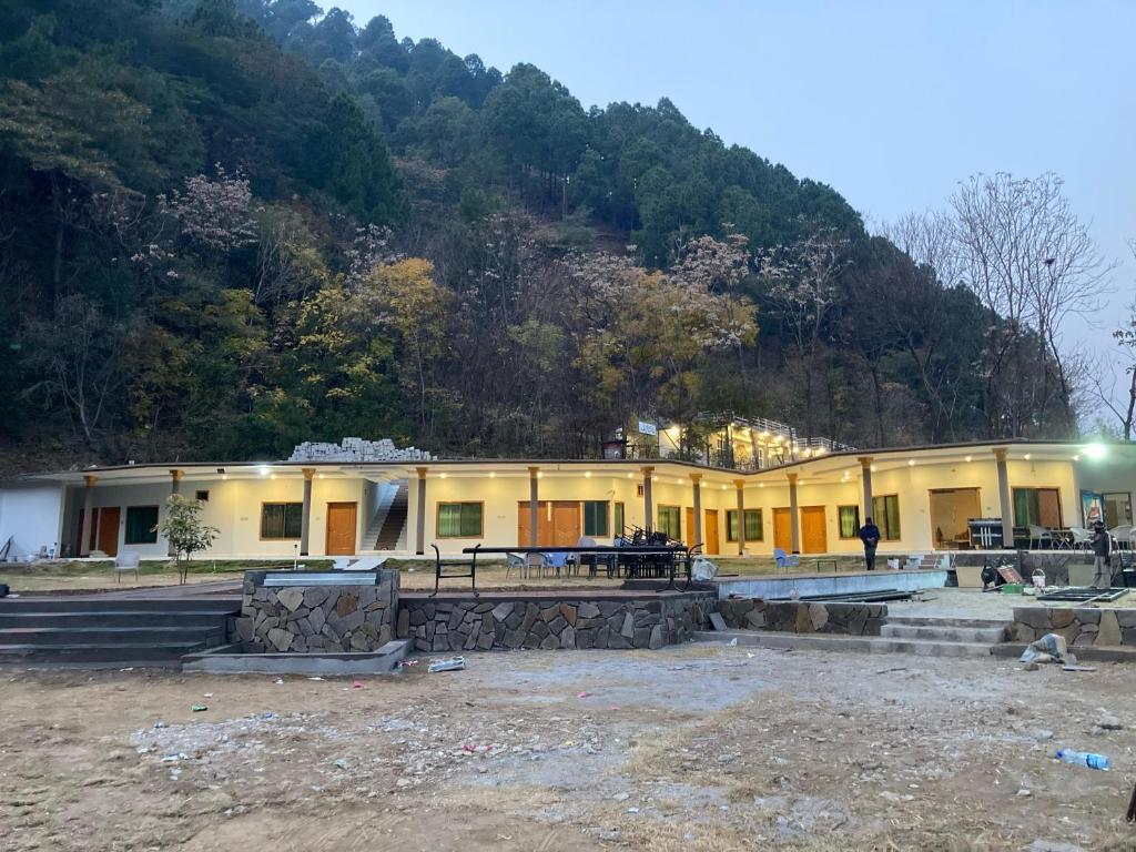 Jharoka Resort - Taranna, Balakot في Hassa: مبنى مع جبل في الخلفية