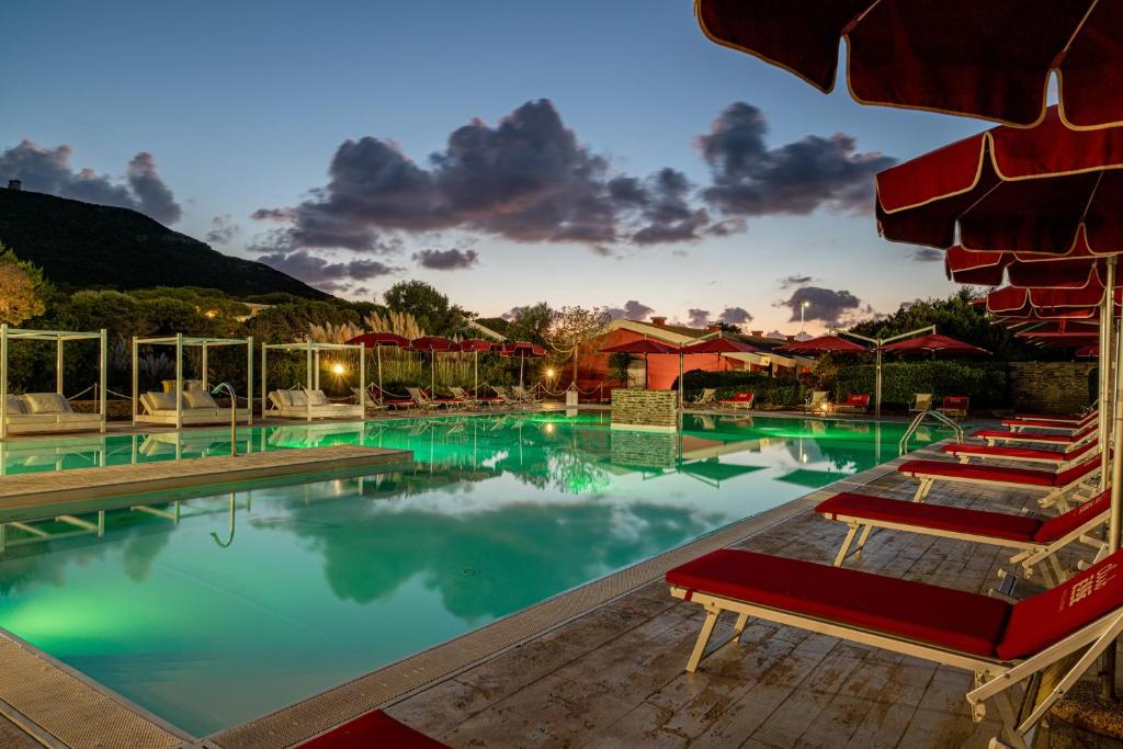 a large swimming pool with a group of chairs at Club Esse Sporting in Stintino
