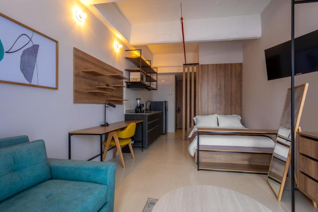 a hotel room with a couch and a bed and a desk at Atelier Ivin 567 in Bogotá