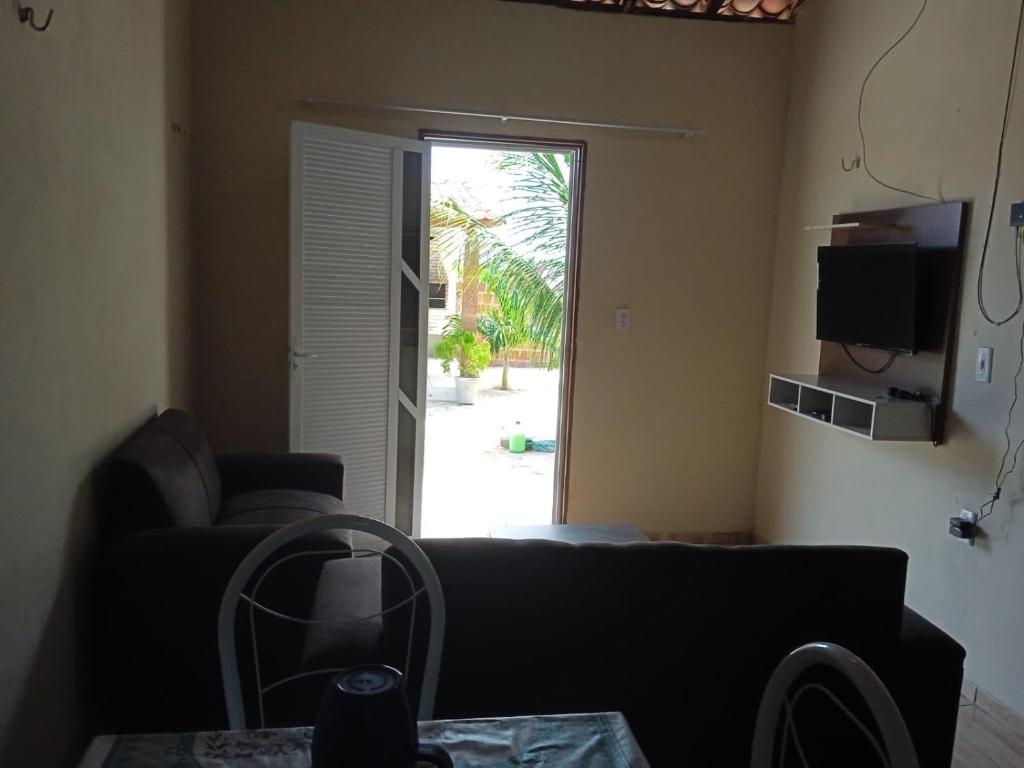 a living room with a couch and a sliding glass door at Condominio Nina2 in Icapuí