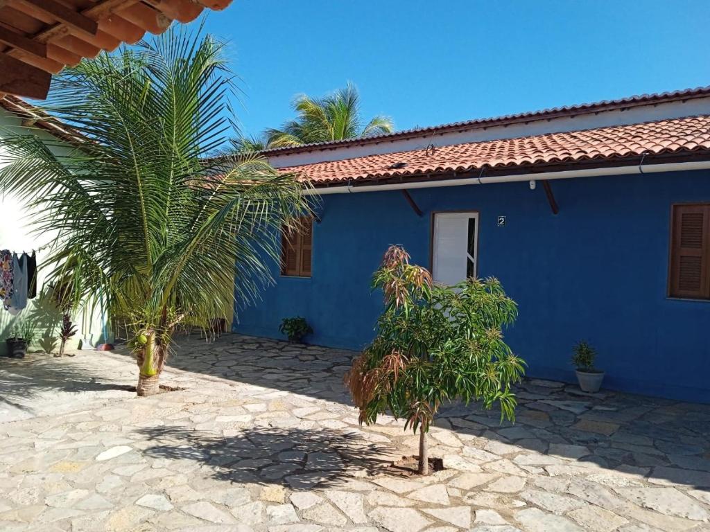 a blue house with a palm tree in front of it at Condominio Nina2 in Icapuí