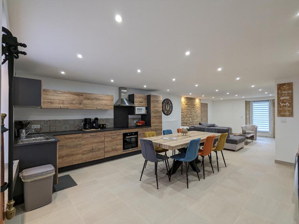 eine Küche und ein Esszimmer mit Tisch und Stühlen in der Unterkunft Gîte élégant avec jardin, proche Luxembourg, Nancy, Metz - FR-1-585-163 in Spincourt