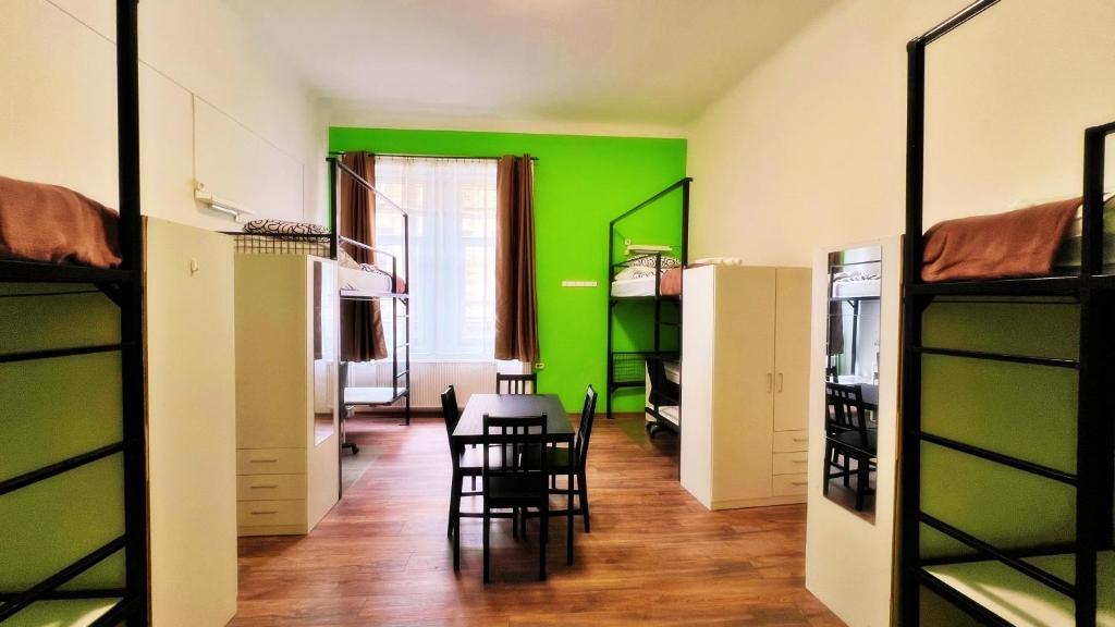 una camera con pareti verdi e tavolo e sedie di BeBudgetRooms a Budapest