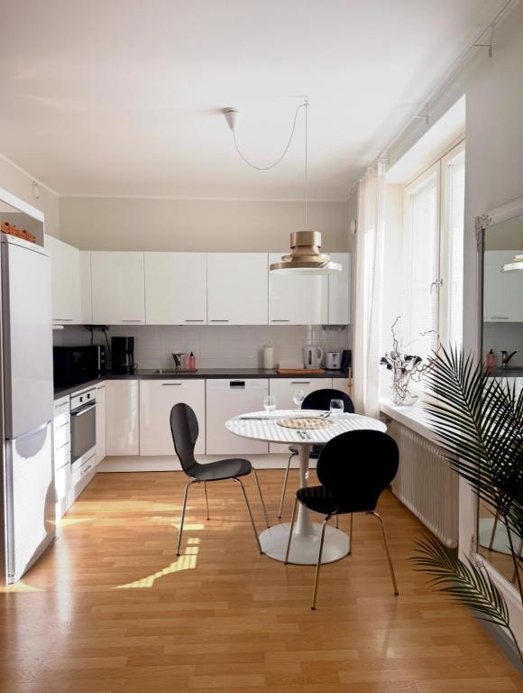 a kitchen with white cabinets and a table and chairs at Villa Centralen in Helsinki
