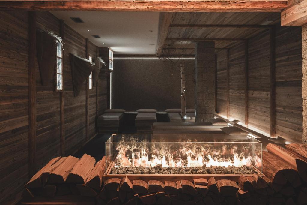 a room with a fireplace and chairs in it at Hotel Selva in Folgarida