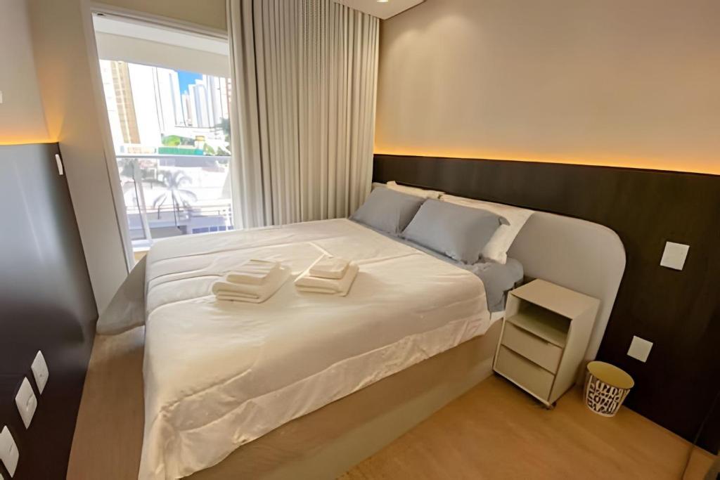 Un dormitorio con una gran cama blanca con ventana. en Bom gosto & Sofisticação Gleba Palhano, en Londrina