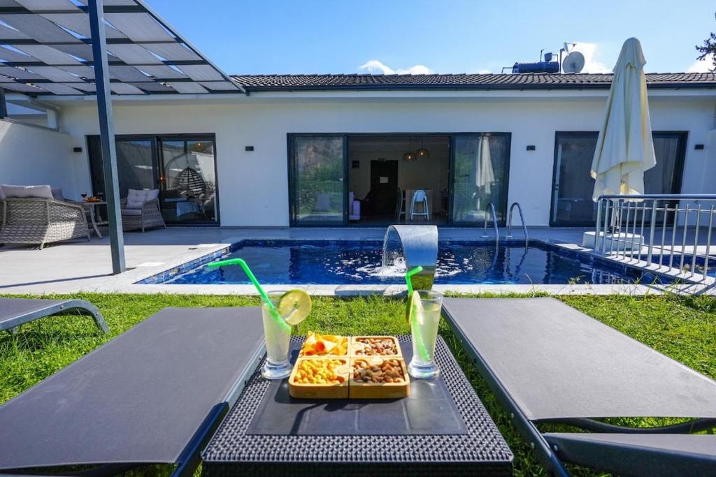 a tray of food on a table next to a pool at Villa Nature Lux in Ortaca