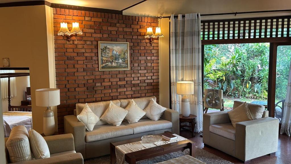 a living room with a couch and a brick wall at 19 St Stephen's in Sri Jayewardenepura Kotte