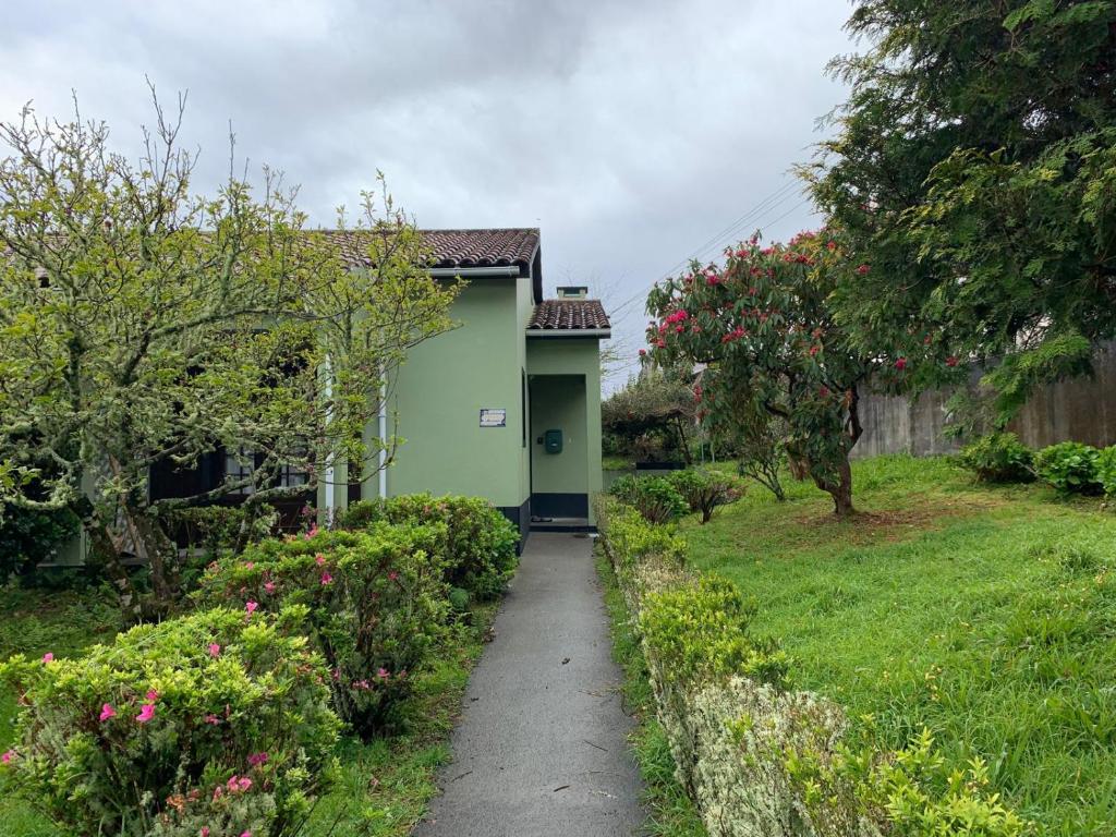 a green house with a walkway in a yard at Residência Mariana in Furnas