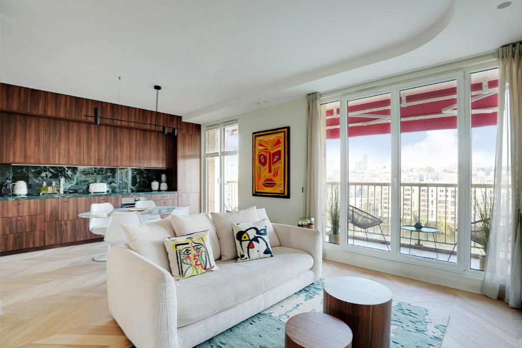 un salon avec un canapé blanc et une cuisine dans l'établissement Riverside Chic Loft, à Boulogne-Billancourt