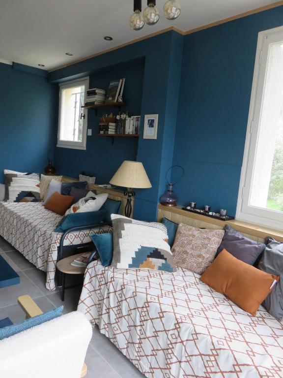 une chambre avec deux lits et un mur bleu dans l'établissement l'ostalet, à Arette