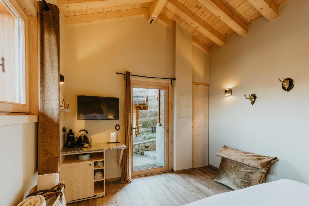 a bedroom with a bed and a sliding glass door at Hôtel Restaurant La Ferme de Cupelin in Saint-Gervais-les-Bains