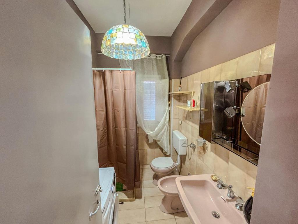 a bathroom with a sink and a toilet and a chandelier at Casa Lucia in Oppido Mamertina