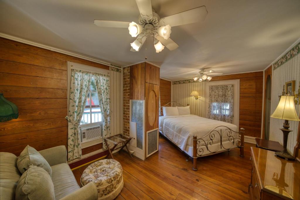 a bedroom with a bed and a ceiling fan at Downtown Magnolia Ste Piedmont in Eureka Springs
