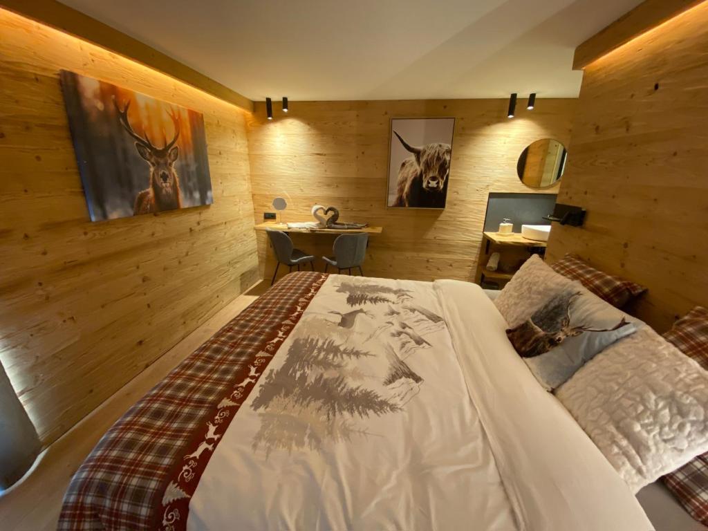 Un dormitorio con una cama en una habitación con paredes de madera. en La Roanneuse - Cosy Chalet, en Francorchamps