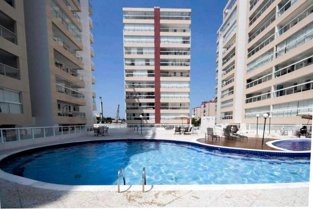 a swimming pool in the middle of two buildings at Apto com lazer completo a 500m da Praia da Enseada in Bertioga