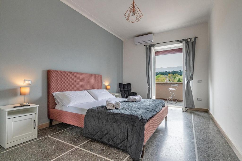 Un dormitorio con una cama y una ventana grande. en Amor Rome Apartments - 6 posti letto e 2 bagni a 4 fermate dal COLOSSEO, en Roma