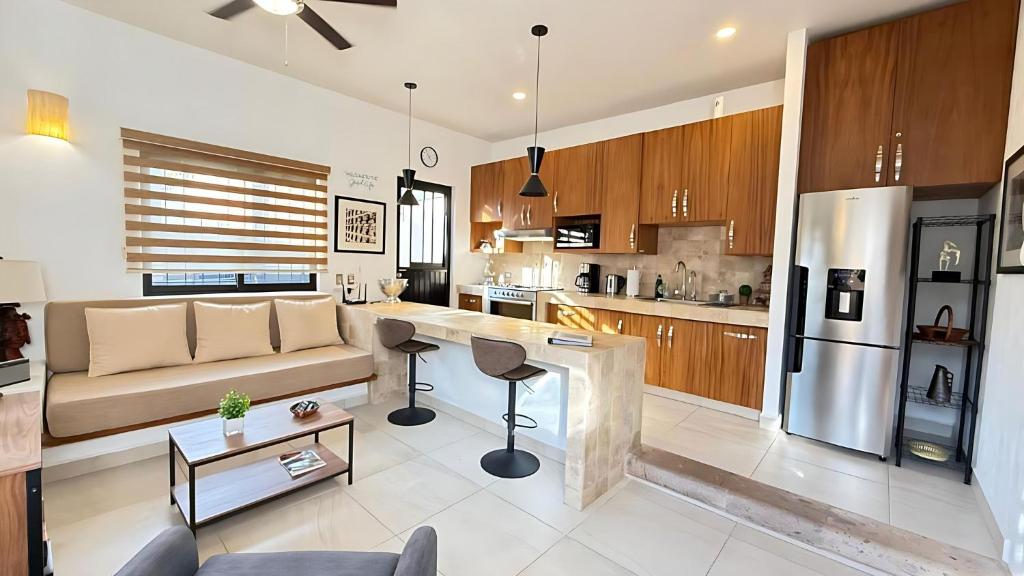 a living room with a couch and a kitchen at Ajijic 1 Bedroom Guesthouse -Walk To Everything -Patio -Bikes - Pickleball Court in Ajijic