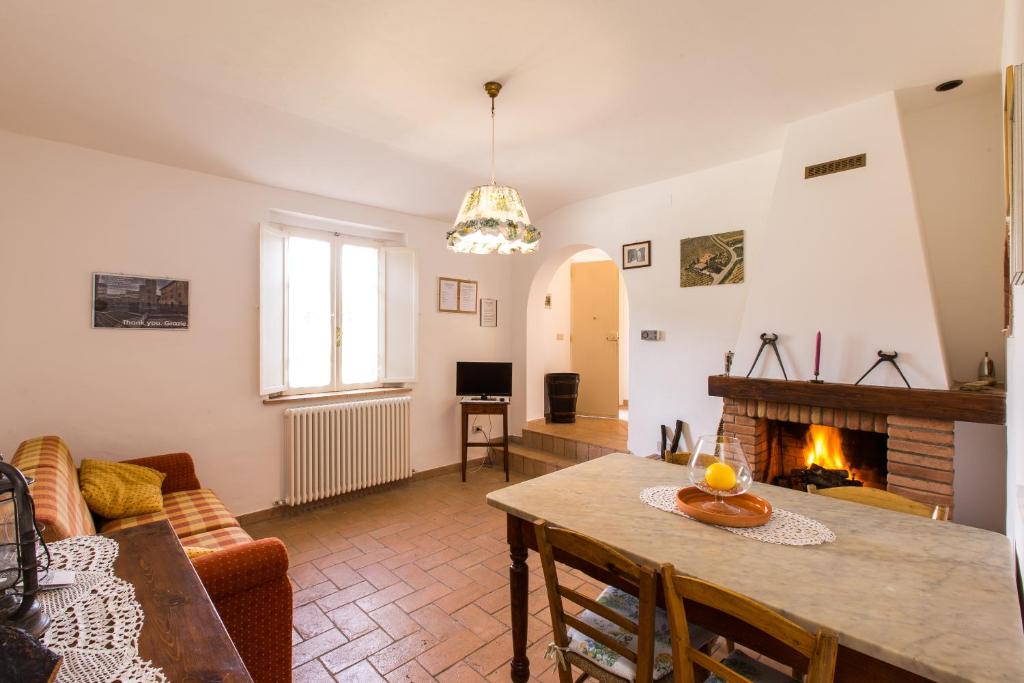 sala de estar con mesa y chimenea en Agriturismo la Vigna, en San Gimignano