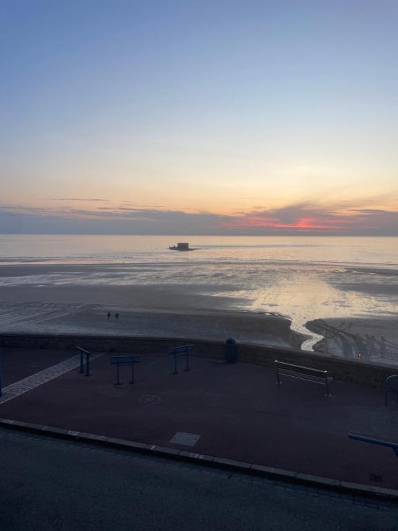 - une vue sur la plage avec un bateau dans l'eau dans l'établissement La Plus Belle vue sur la Mer, à Le Portel