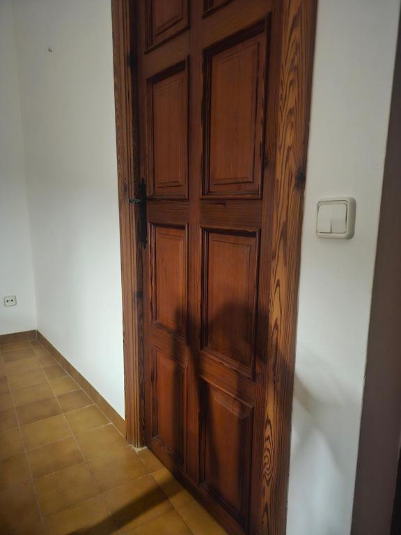 Cette chambre dispose de carrelage et d'une porte en bois. dans l'établissement Son morell, à Muro
