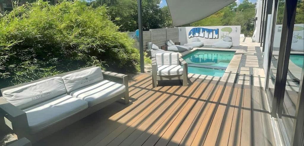 a deck with a couch and two chairs next to a pool at Modern 2-Home Private Oasis w Pool Hot Tub in DT in Austin