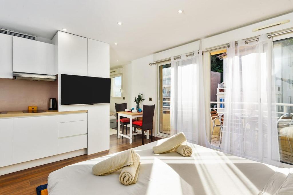 Cette chambre blanche dispose d'un lit et d'une cuisine. dans l'établissement Monte carlo riviera, à Beausoleil