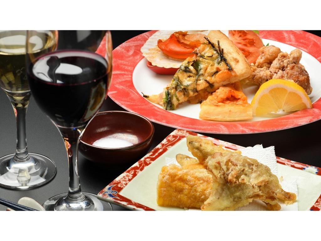 einen Tisch mit zwei Teller Essen und einem Glas Wein in der Unterkunft Hotel Grand Mer Sankaiso - Vacation STAY 69635v in Kawajiri