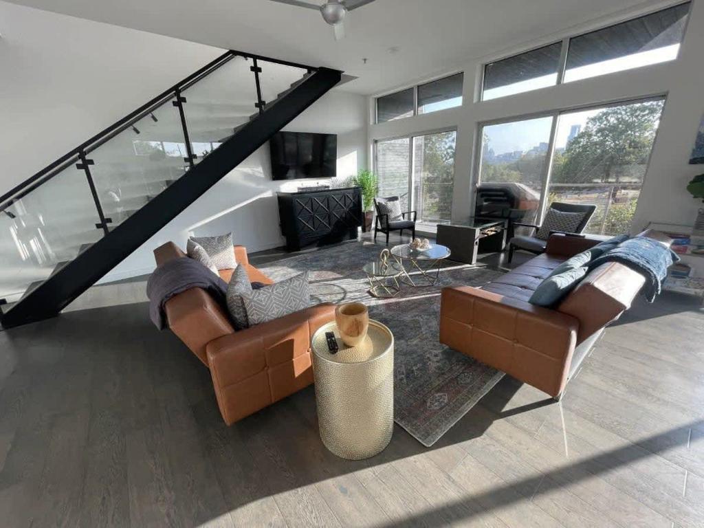 a living room with leather couches and a fireplace at Game Day Penthouse Steps from UT Sports in Austin