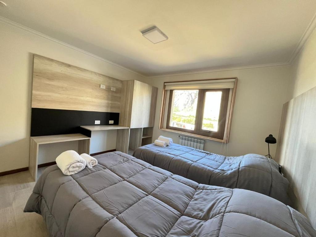 a bedroom with two beds and a window at De los Tres in El Chalten