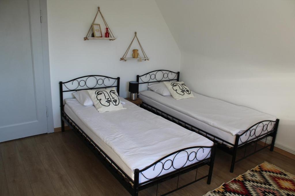 two beds in a room with white walls at AP Apartment's Rodzinny in Wałbrzych