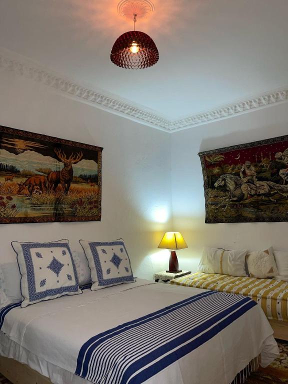 a bedroom with a bed with blue and white sheets at Dar hana in Asilah