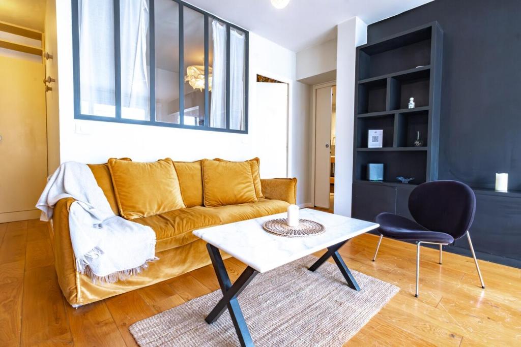 un salon avec un canapé et une table dans l'établissement Appartement Invalides avec Terrasse, à Paris