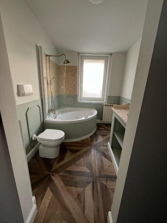 a bathroom with a tub and a toilet and a sink at Locanda Gaudemus Boutique Hotel in Sistiana
