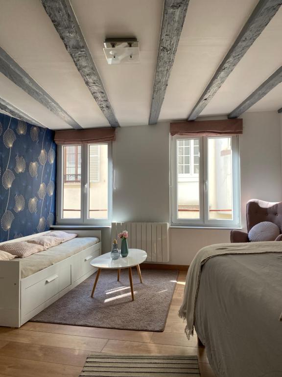 une chambre avec un lit et une table et deux fenêtres dans l'établissement BEAU studio dans l hyper centre, à Strasbourg