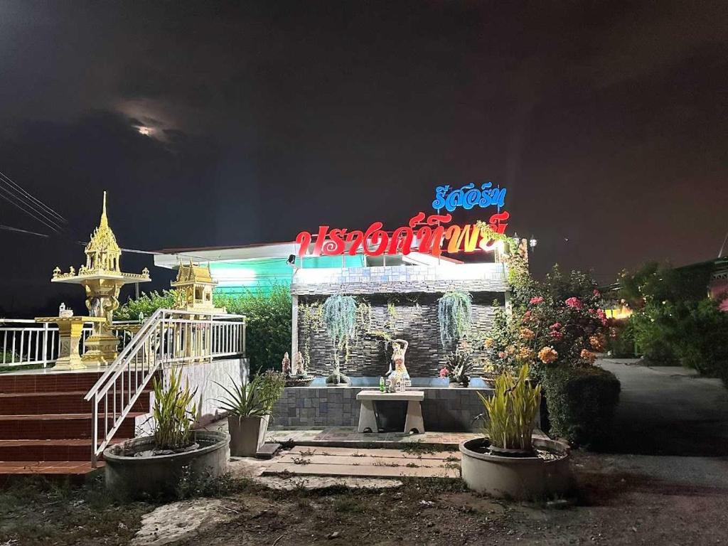 a building with a neon sign in front of it at OYO 75487 Prang Thip 306 Resort in Bangkok