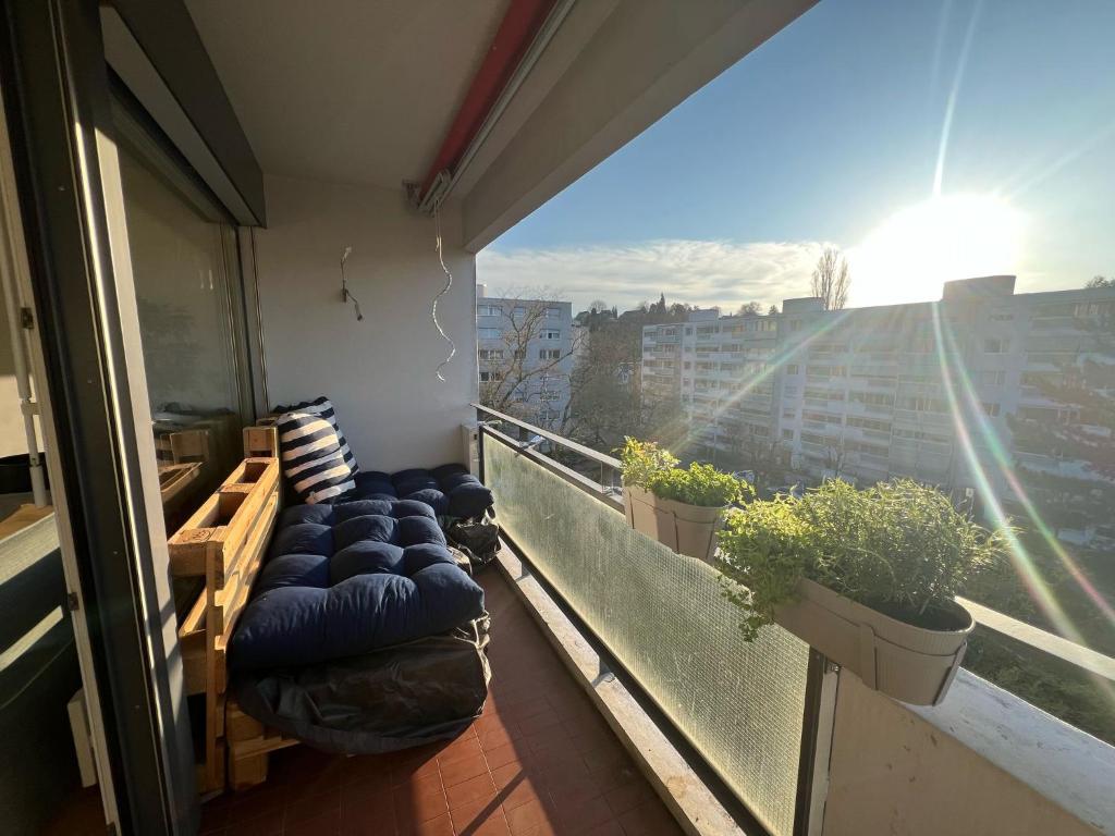 - un balcon avec des oreillers et des plantes bleus dans un bâtiment dans l'établissement Möbelierte Wohnung mit Balkon zwischen Bahnhof und St Jakob, à Bâle