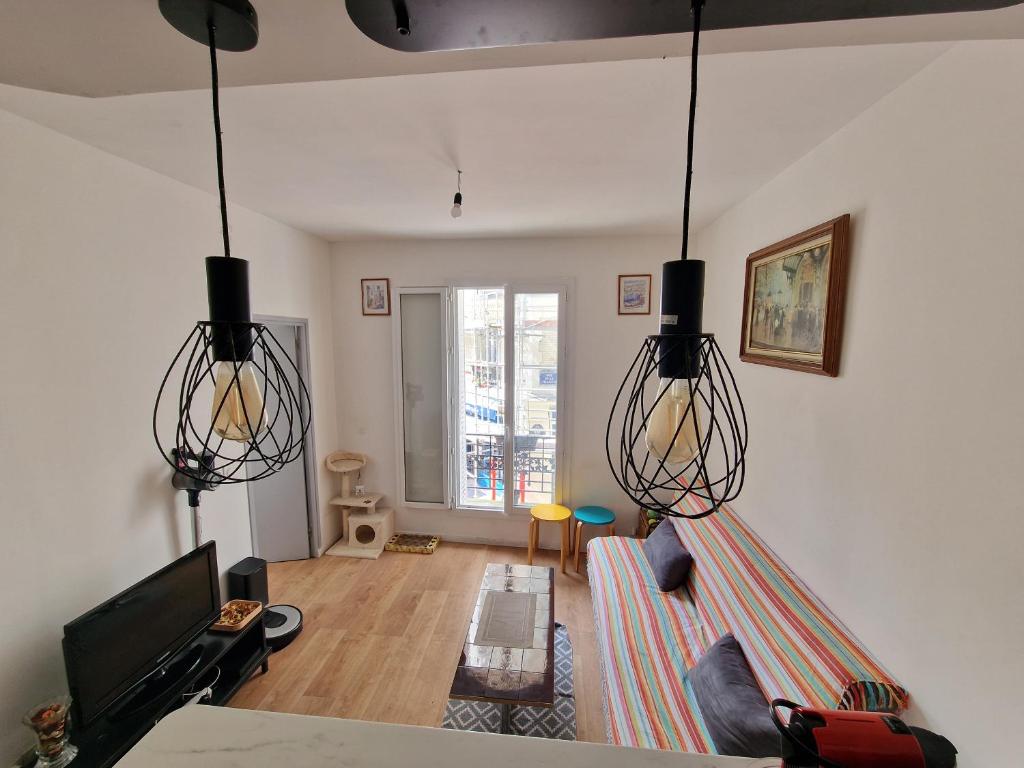 - un salon avec deux lampes suspendues et un canapé dans l'établissement Un magnifique appartement a Paris Jourdain, à Paris