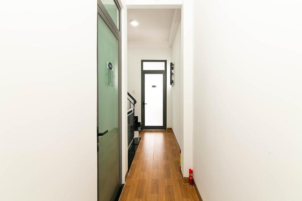 un corridoio con pareti bianche e pavimenti in legno di SPOT ON 806 Net Viet Homestay a Da Nang