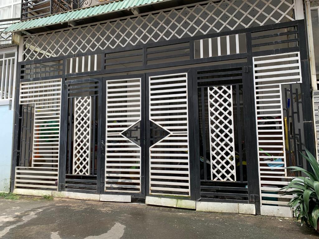 un bâtiment noir et blanc avec un signe de rendement sur celui-ci dans l'établissement OYO 1248 Quyen House, à Đà Lạt