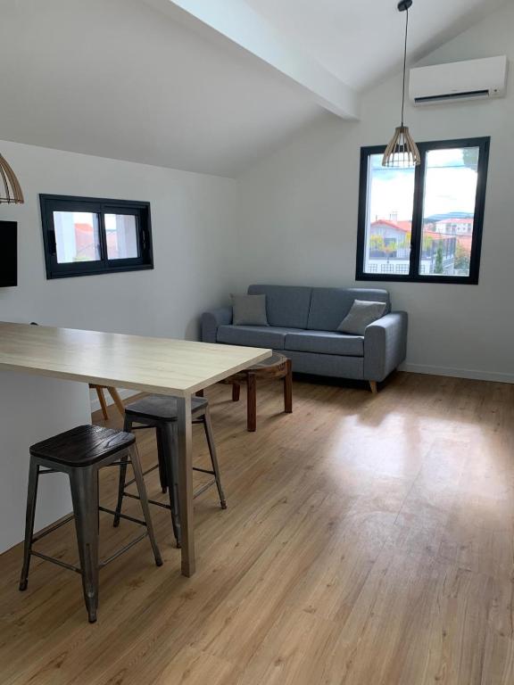 un salon avec une table et un canapé dans l'établissement Azkena, à Anglet