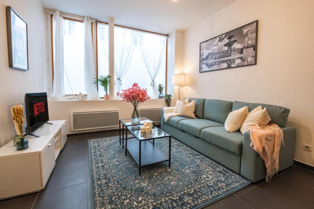 un salon avec un canapé vert et une table dans l'établissement Elegant Duplex Montorgueil - 6 Guests, à Paris