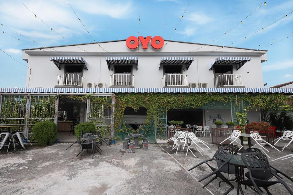 a building with chairs and tables in front of it at OYO 778 Bmw 2 Hotel in Muar