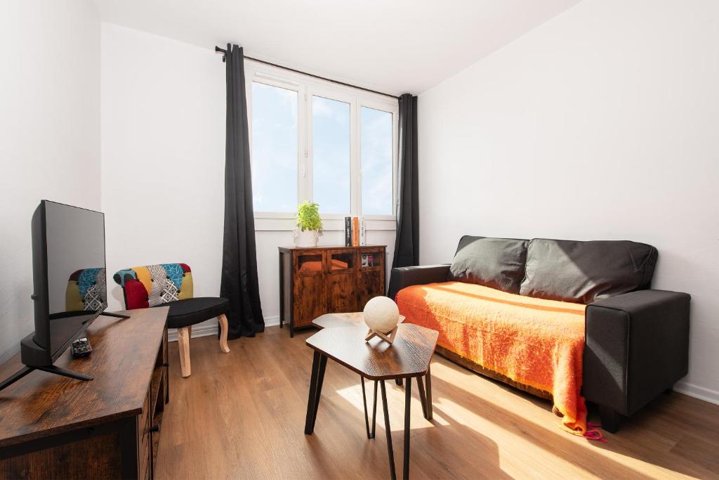 une chambre avec un lit, un canapé et une télévision dans l'établissement L Horizon Saint Cyprien, à Toulouse