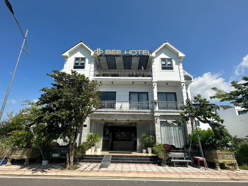 a white building with a blue sign on it at Capital O 1194 Bee Hotel in Xóm Cầu Hin